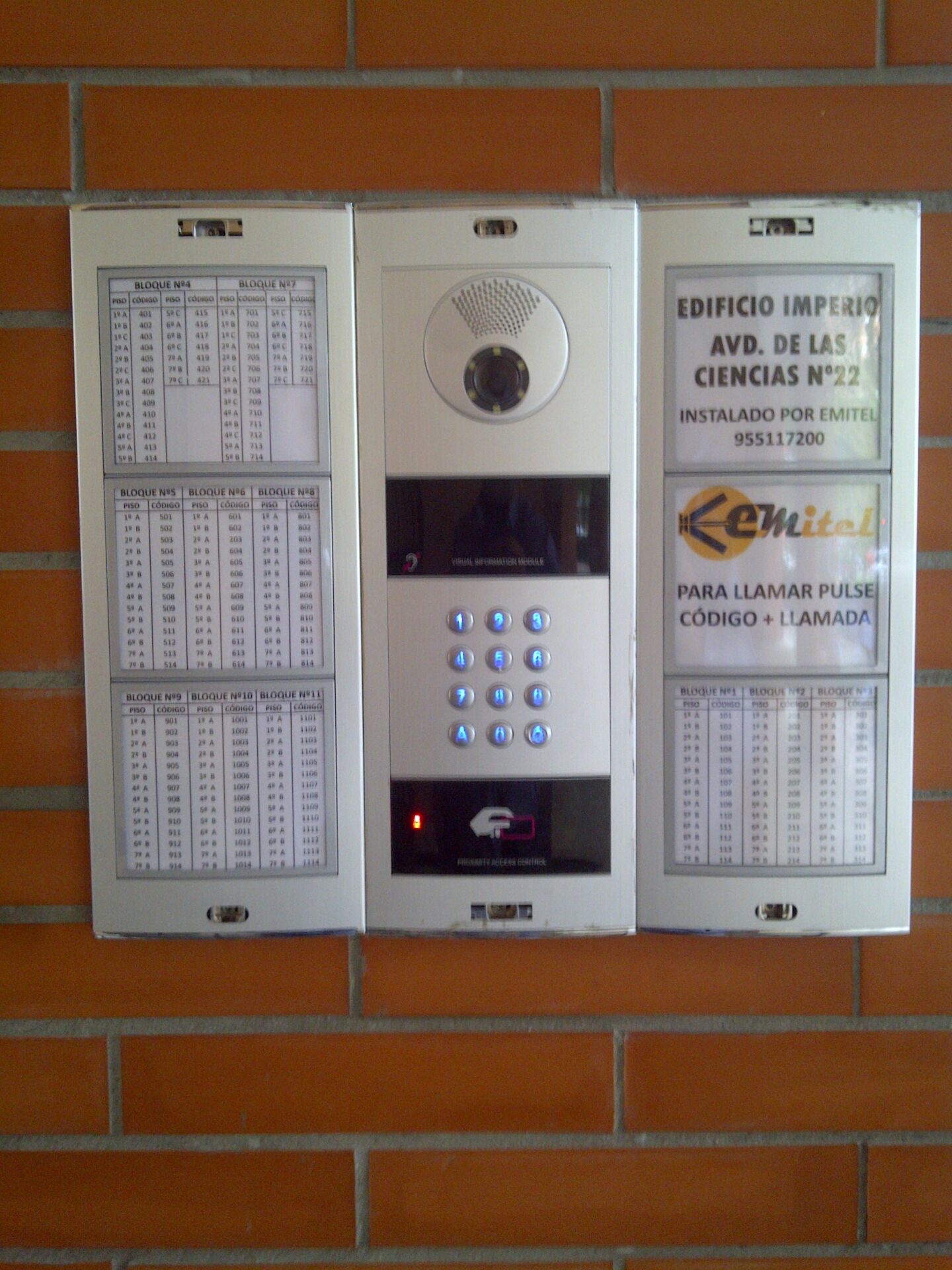 Pared equipada con videoporteros de 11 bloques y un teléfono, utilizada para la comunicación o el acceso a servicios.