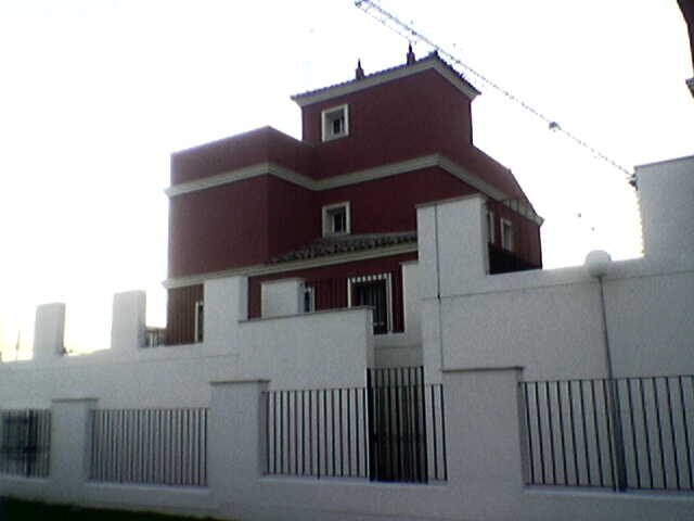 Chalet rojo con muro de piedra gris