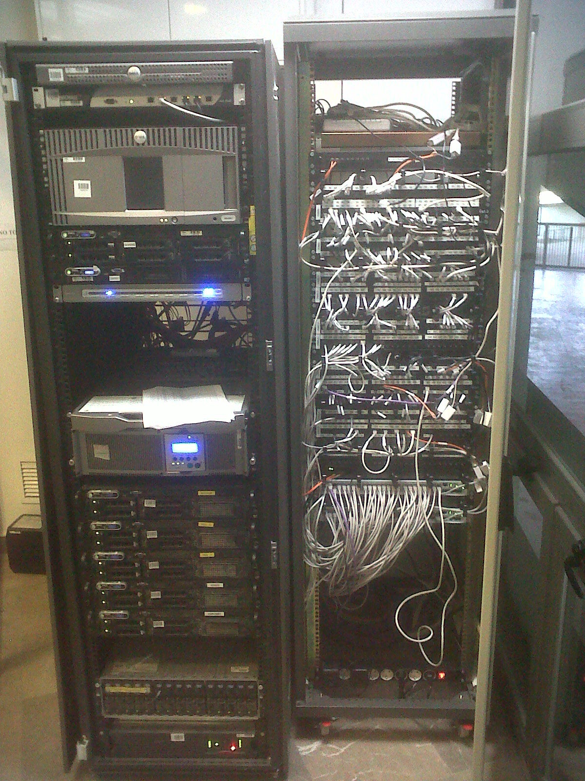 Rack que muestra computadoras y servidores, dispuestos de manera ordenada en un espacio de trabajo tecnológico.